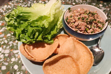 close up of Thai Asian food, Thai Minced Pork with Lettuce Wrap on a blue plate