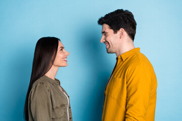 Profile portrait of two young people look each other wear shirt isolated on blue color background