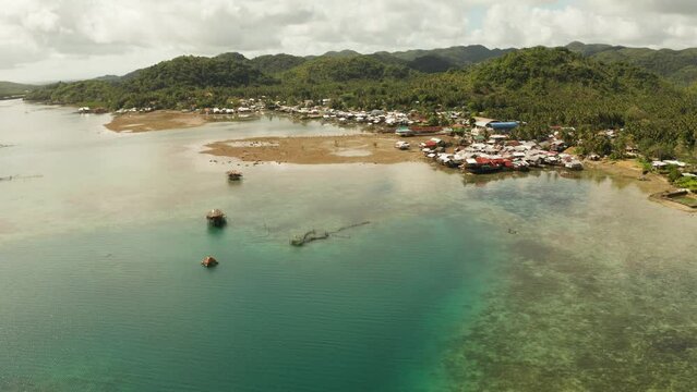 Village of stilt houses built over the sea, top view. Dapa, Siargao, Philippines.