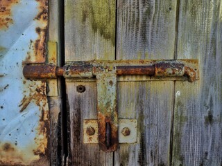 Vintage Rustic Security: Aged Wooden Door with Weathered Metal Latch, Perfect for Antique Charm Themes - Find Unique Textures and Timeless Stories in Every Detail