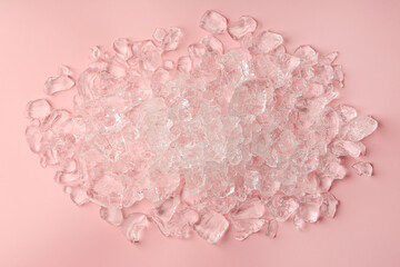 Pieces of crushed ice on pink background, top view