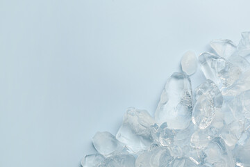 Pieces of crushed ice on light blue background, top view. Space for text