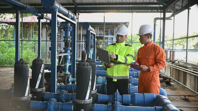 Engineer and technician maintenance checking technical data of system equipment Condenser Water pump and pressure gauge,environmentalist working at water supply