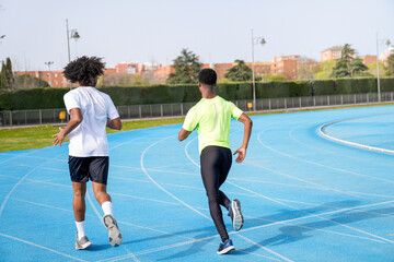 Fototapeta premium Two african young men running on a track
