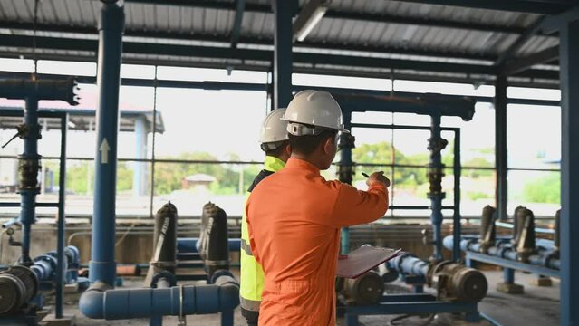 Engineer and technician maintenance checking technical data of system equipment Condenser Water pump and pressure gauge,environmentalist working at water supply