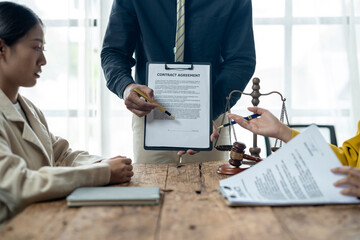 A man is holding a contract in front of a woman and another man