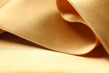 Beautiful golden ribbon as background, closeup view