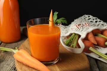 Healthy juice and fresh carrot on wooden table