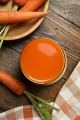 Healthy carrot juice in glass and fresh vegetables on wooden table, top view