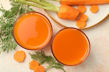 Healthy carrot juice in glasses and fresh vegetables on color textured table, top view