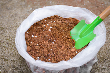 Soil fertilizer peat moss or cocopeat in bags and soil shovels are used for planting crops or...