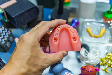Dental technician modeling teeth frame for implant production from a 3d printer at the laboratory