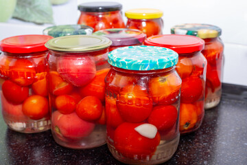 Red ripe tomatoes in glass jars. Salting and pickling vegetables for the winter