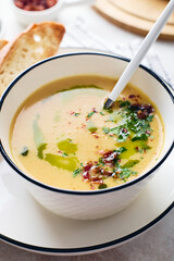 Bowl of potato soup with parsley and bacon with toasted bread croutons in white bowl. Comfort meal