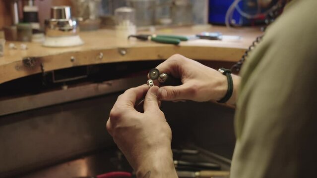 A man is working on a project, holding a small object in his hand