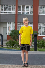 Full body portrait of a little boy wearing a yellow t-shirt