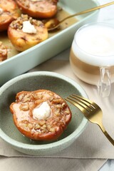 Tasty baked quinces with nuts and cream cheese served on table