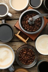 Different coffee drinks in cups, beans and manual grinder on wooden table, flat lay