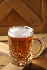 Mug with fresh beer on wooden crate