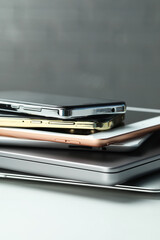 Stack of electronic devices on white table, closeup