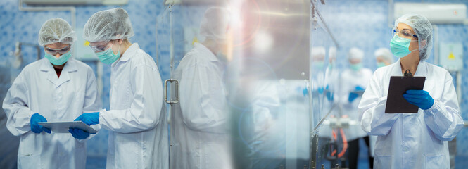 Female factory workers check machine systems at the industrial factory. Women working in clean rooms for beverage and food production