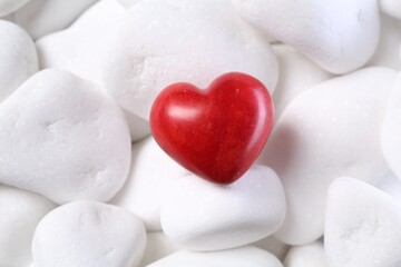 Obraz premium Decorative heart on white pebble stones, top view