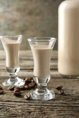 Coffee cream liqueur in glasses and beans on wooden table