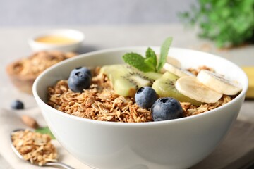 Tasty granola with fresh fruits on grey table, closeup