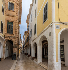 Charming and picturesque streets of Ciudadela. Cozy arcades formed by arches in various shades of color. Menorca, Spain