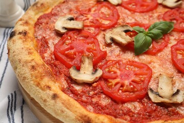 Delicious pizza with tomatoes, mushrooms and basil on table, closeup