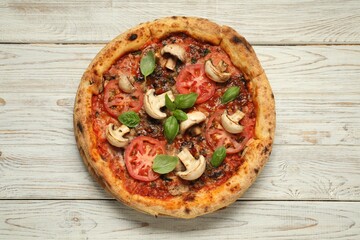 Tasty pizza with basil, mushrooms and tomato on wooden rustic table, top view