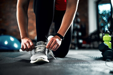 Runner, hands and tying shoes for training, fitness and exercise or running with sneakers, fashion and getting ready. Person or athlete with laces and legs or feet for cardio, health and wellness gym