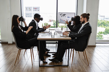 Business team using virtual reality headsets in modern office meeting. Colleagues demonstrating innovative technology during work presentation. Concept of teamwork, innovation, and technology.