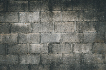 A wall made of gray bricks with a rough texture