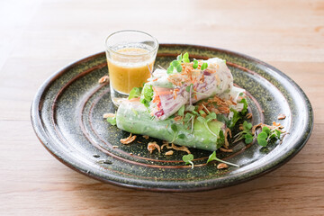 A plate of food with a green salad and a dipping sauce