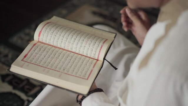 Close up of a Muslim's hand holding the Koran in the mosque. Muslims will reading koran more often in the month of Ramadan.