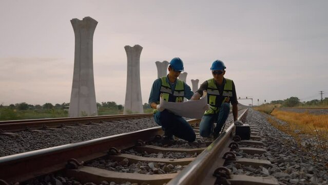 Engineers and technicians are inspecting and surveying the construction of railway tracks for construction of transportation systems, engineering concepts, construction, infrastructure systems.
