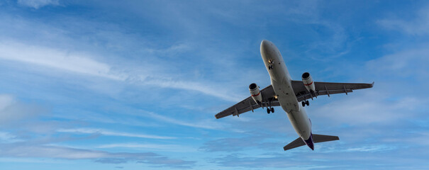 Airplane and sky, the plane is landing. Airplane take off on the blue sky, Aircraft flying on sky background. Passenger plane ready for landing. Low angle view of Airplane flying under blue sky