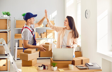 Happy chief is giving a high five to a worker in a warehouse, shop, or postal office, celebrating success. Positive and encouraging work environment, highlighting the team achievements.