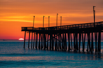 sunrise or sunset on the pier by the ocean