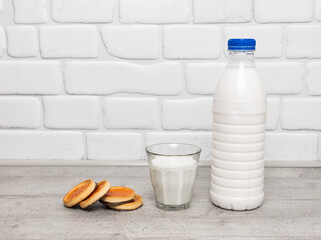bottle and a glass of milk with cookies on the kitchen table