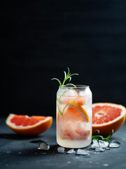 Summer cold cocktail with gin grapefruit and rosemary on a black background