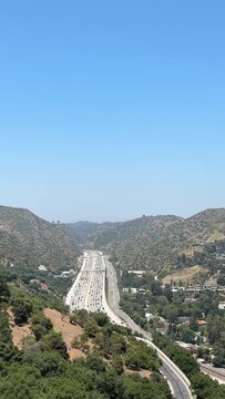 Views of the freeway from the Getty Center. The Angels. Busy highway traffic at sunset with view of nearby hills.
