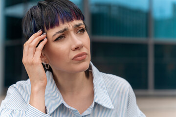 Woman With Short Hair Holding Her Forehead In Thought