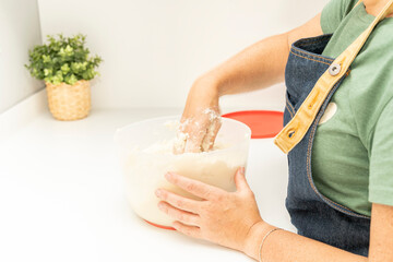 Close up of a woman's hands preparing arepa dough with corn flour in a bowl. High quality photo