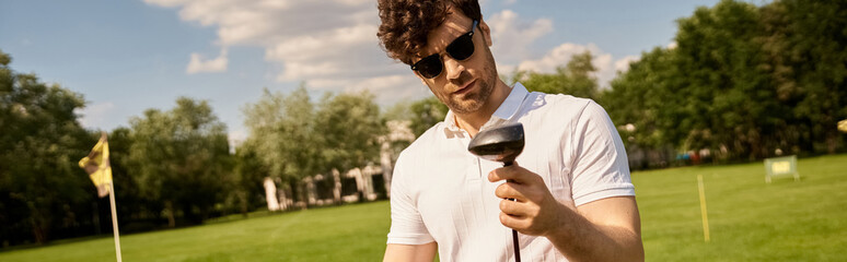A sophisticated man in elegant attire swings a golf club in a lush green field, exuding an air of...