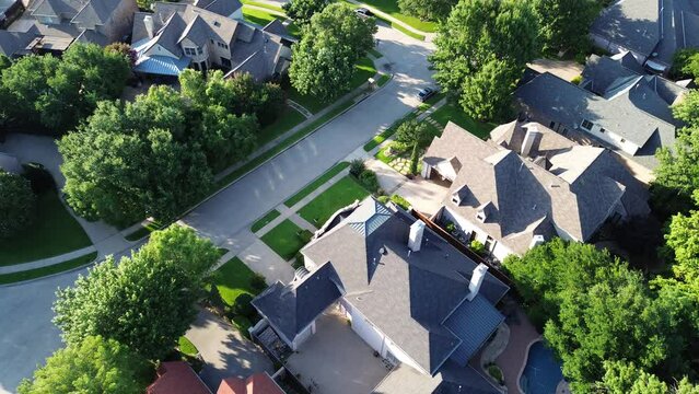 Flyover cul-de-sac dead end street in upscale suburbs Dallas residential neighborhood expensive two-story suburban mansion houses lush greenery trees, well-trimmed front yard landscape, Texas