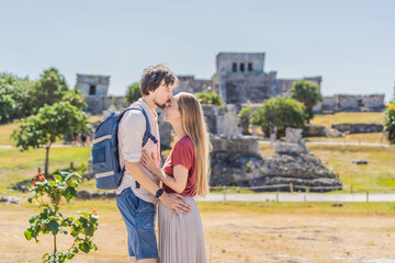 Fototapeta premium Couple man and woman tourists enjoying the view Pre-Columbian Mayan walled city of Tulum, Quintana Roo, Mexico, North America, Tulum, Mexico. El Castillo - castle the Mayan city of Tulum main temple