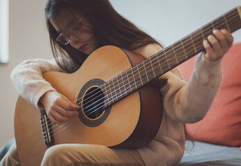 Little girl plays the guitar.