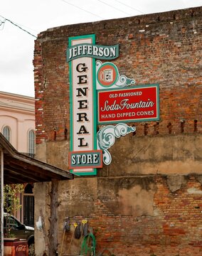 Historic sign for Jefferson General Store attached to the side of an old brick wall advertising 5-cent coffee, old-fashioned soda fountain, and hand-dipped cones in East Texas.